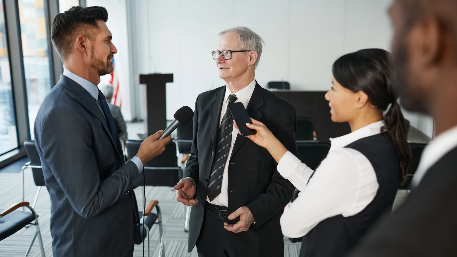 Journalists interviewing a business leader at a press event.