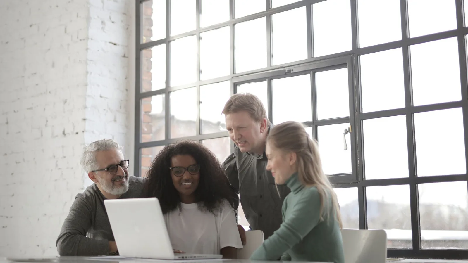 A small business team collaborating around a laptop.